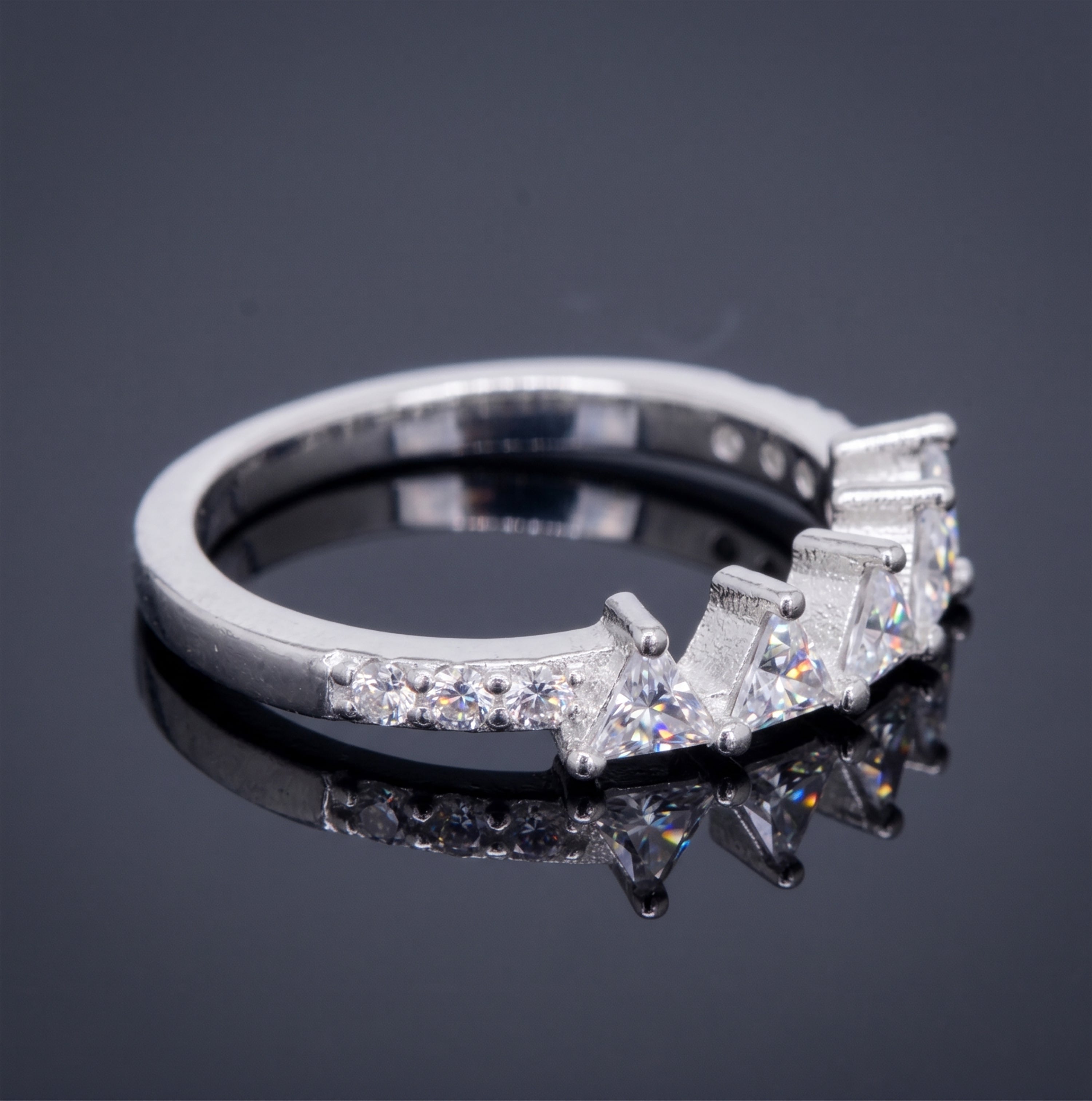 Side profile of a handcrafted silver crown ring showing the sculptural wishbone band and secure stone settings